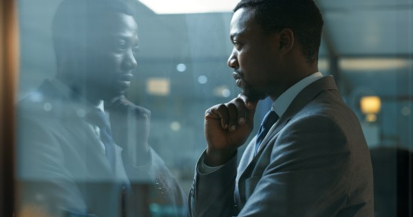 Business man standing in his office at night