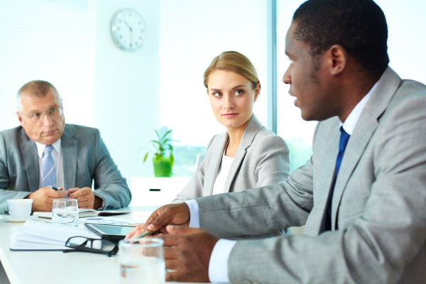 Three business people having a discussion at a table.